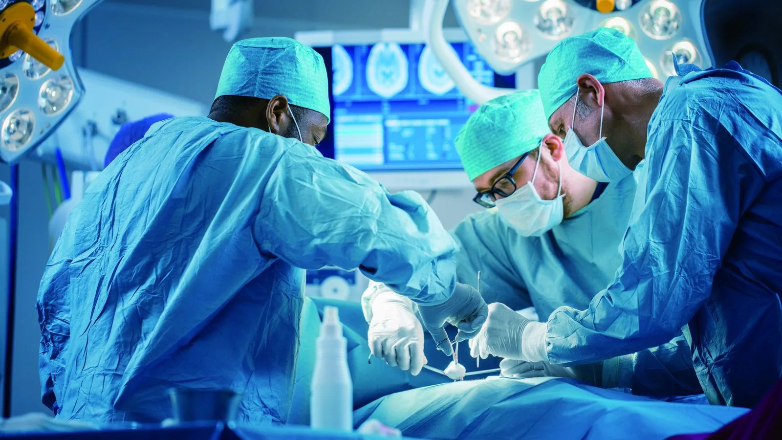 Surgical team wearing disposable medical gloves in an operating theatre